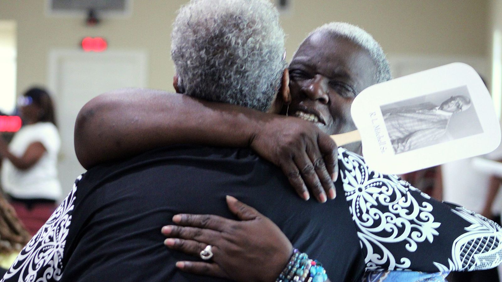 Two members embracing after service